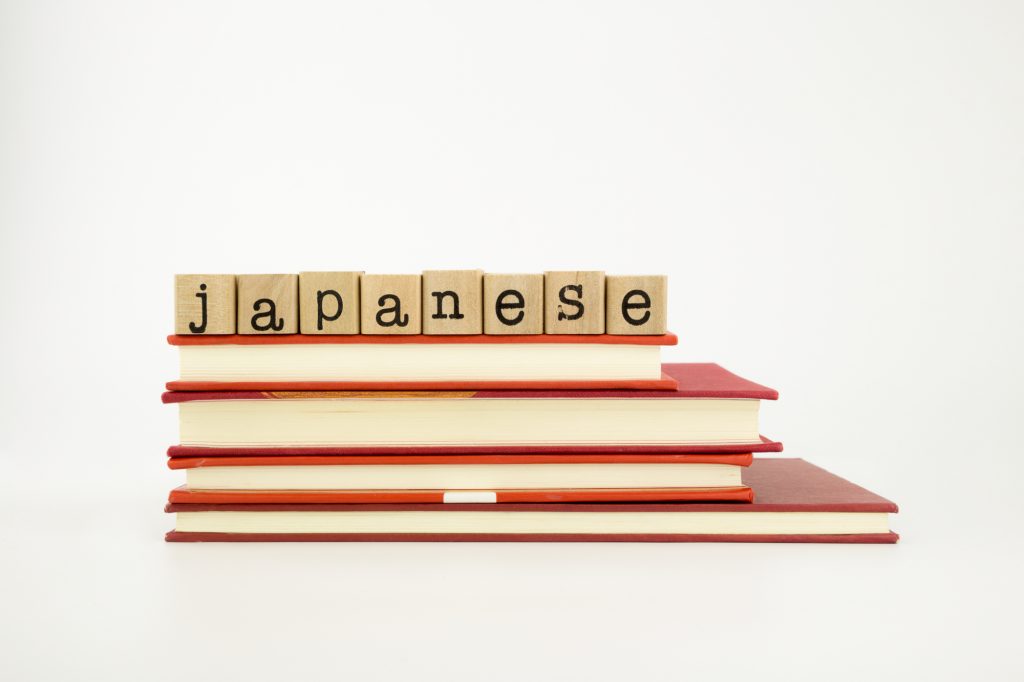 japanese word on wood stamps stack on books, language and academic concept