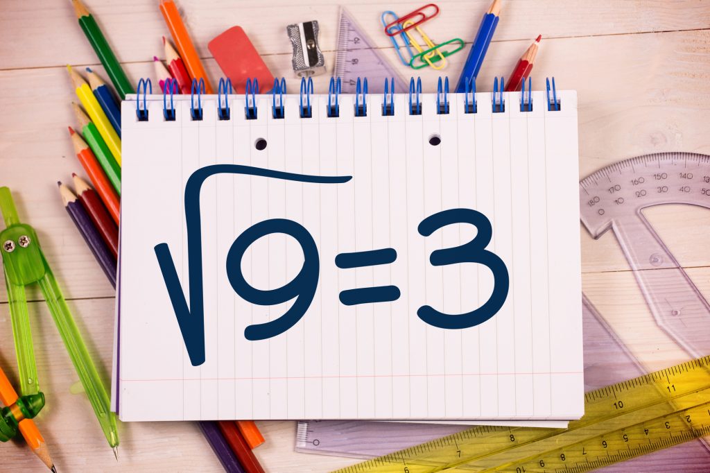Square root of three on notepad against students desk