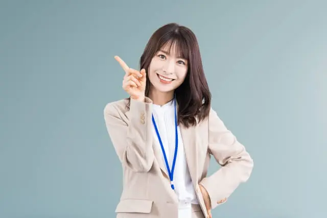 人差し指を立てている塾講師