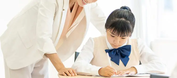 学校教材を使って指導する講師と生徒